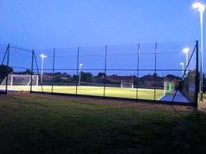 astroturf pitch under flood lights