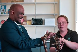 ACS teacher holding a snake as part of Open Day Science activities