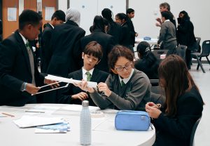 Y7 students building a bridge out of straws and tape 