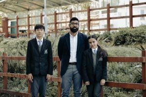 Alumni Tayyab Rahman with two Alperton students