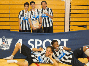 Josiah (top right), Theo (bottom left) and teammates with the trophy.
