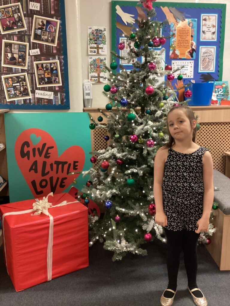 Child standing in front of a Christmas Tree