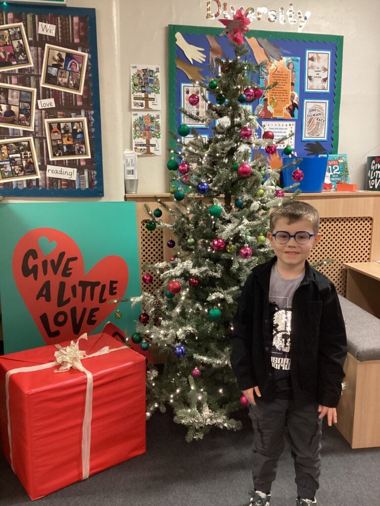 Child standing in front of a Christmas Tree