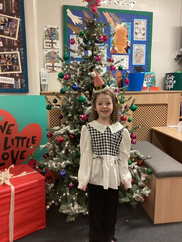 Child standing in front of a Christmas Tree