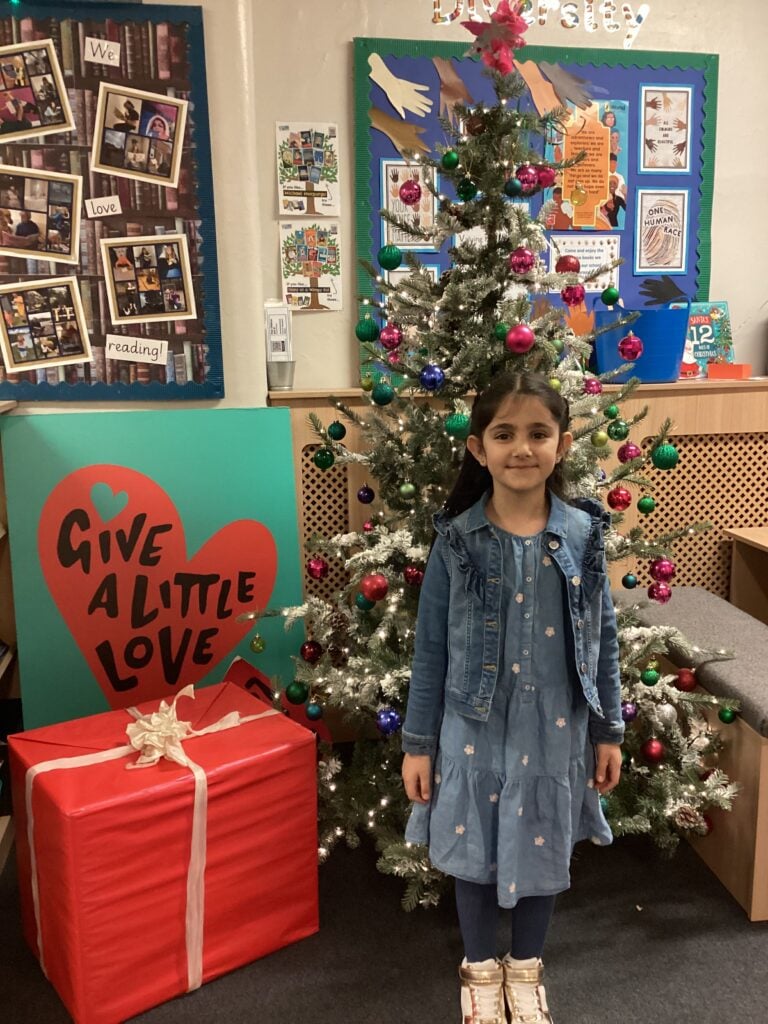 Child standing in front of a Christmas Tree