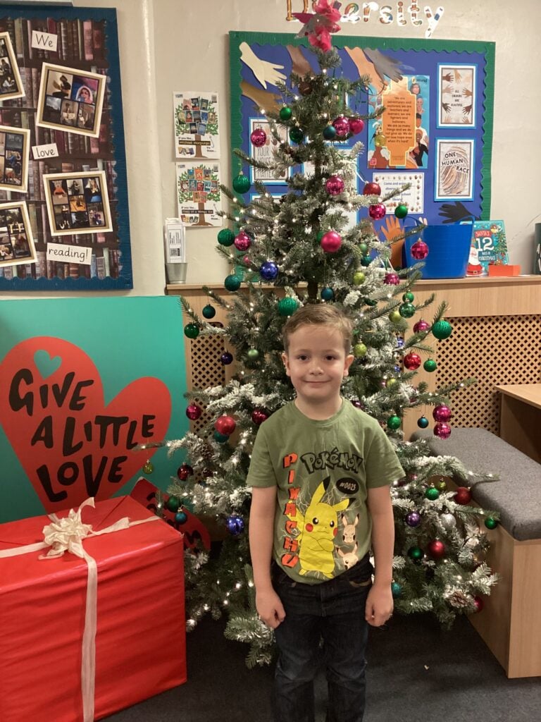 Child standing in front of a Christmas Tree