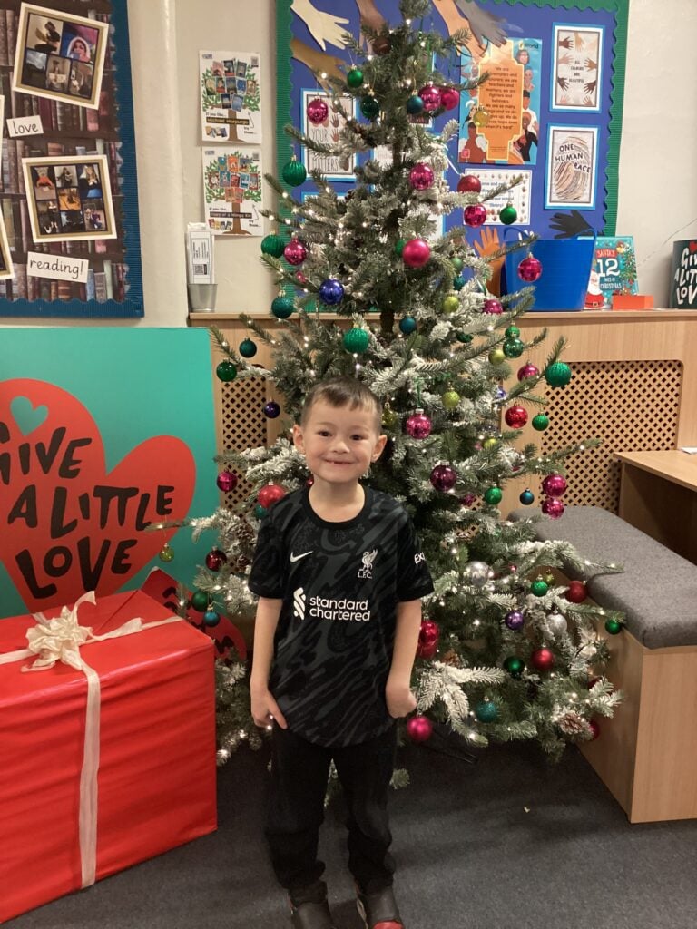 Child standing in front of a Christmas Tree