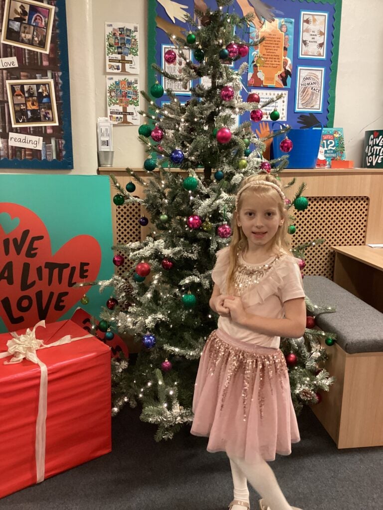 Child standing in front of a Christmas Tree