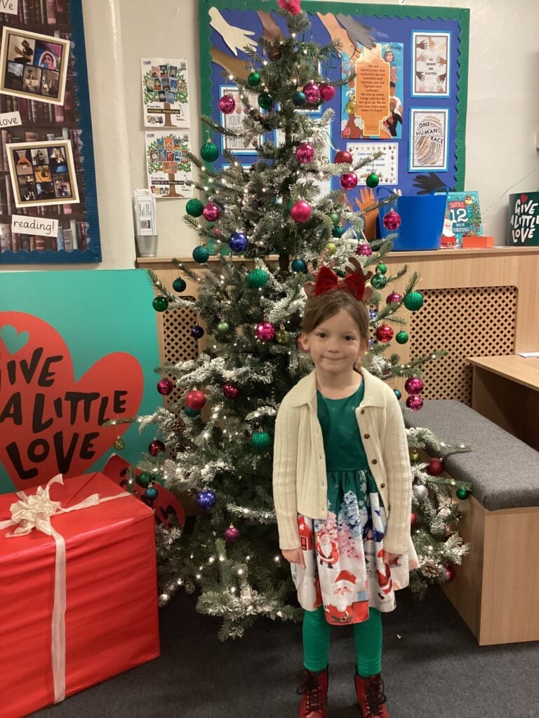 Child standing in front of a Christmas Tree