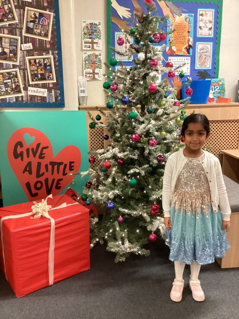 Child standing in front of a Christmas Tree