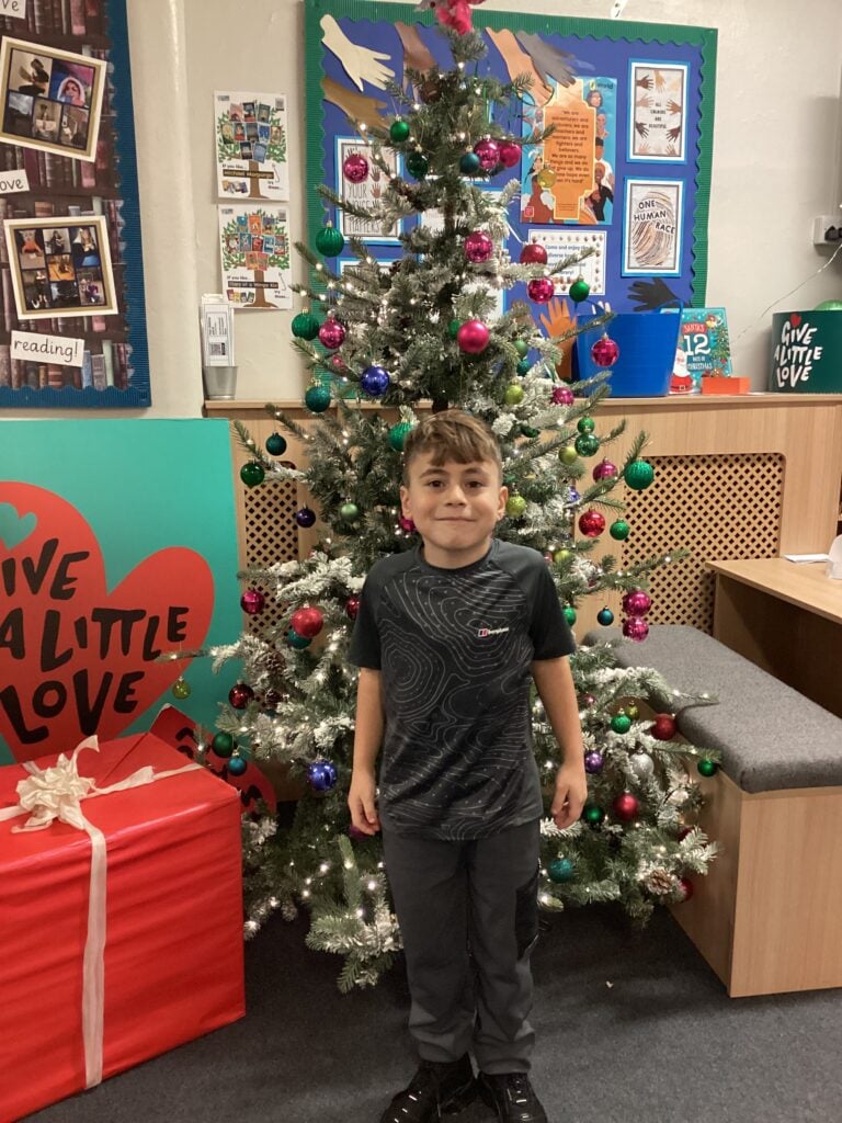 Child standing in front of a Christmas Tree