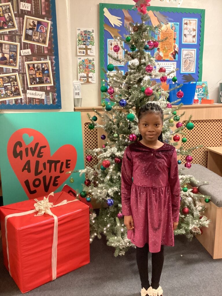 Child standing in front of a Christmas Tree