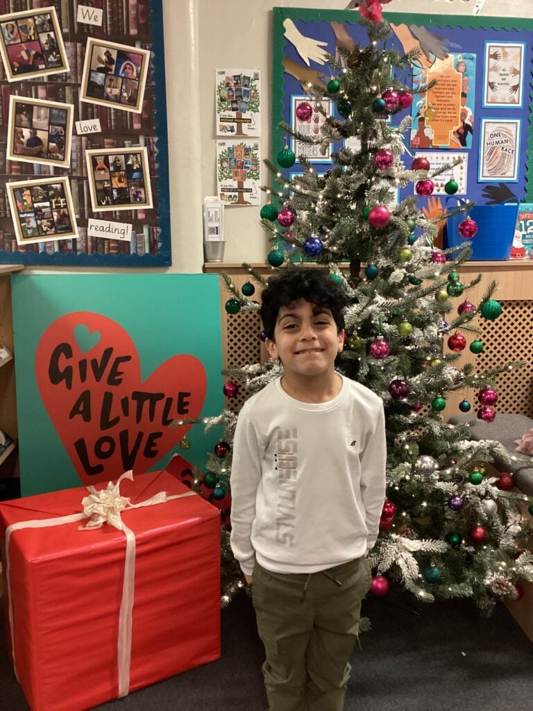 Child standing in front of a Christmas Tree