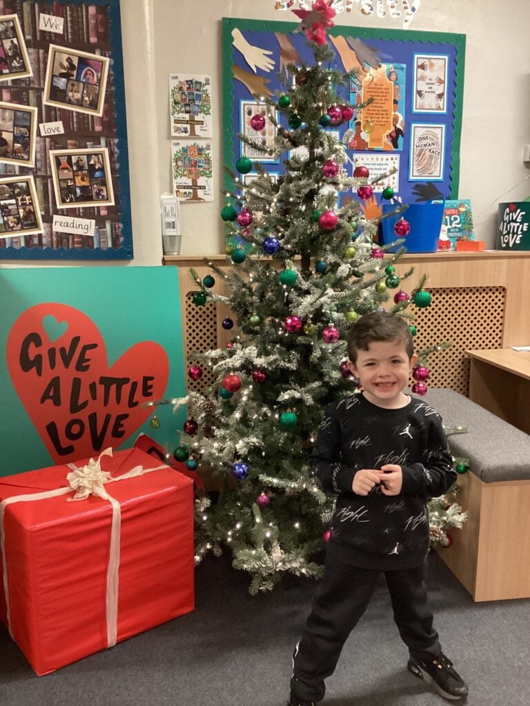 Child standing in front of a Christmas Tree