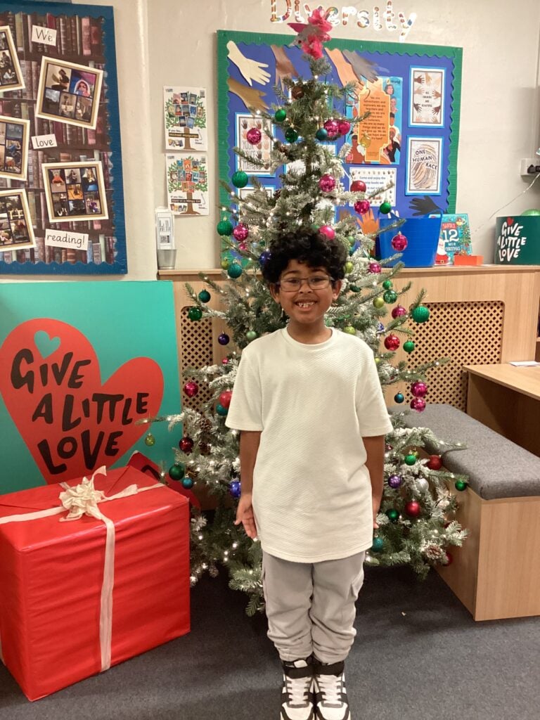 Child standing in front of a Christmas Tree