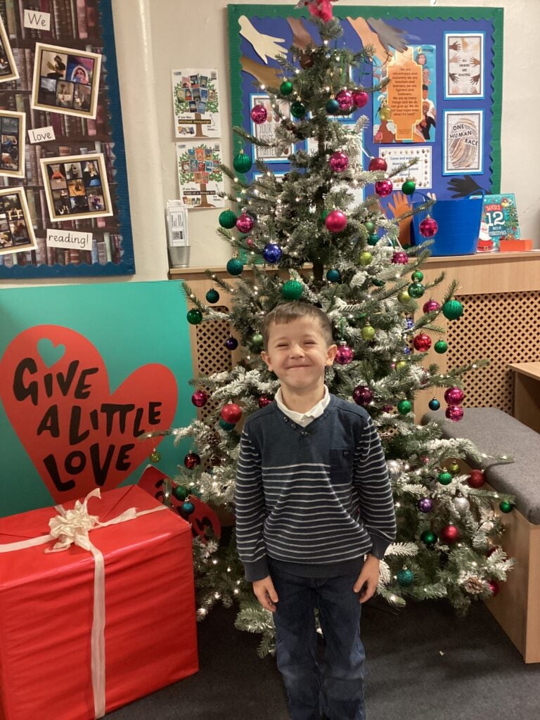 Child standing in front of a Christmas Tree