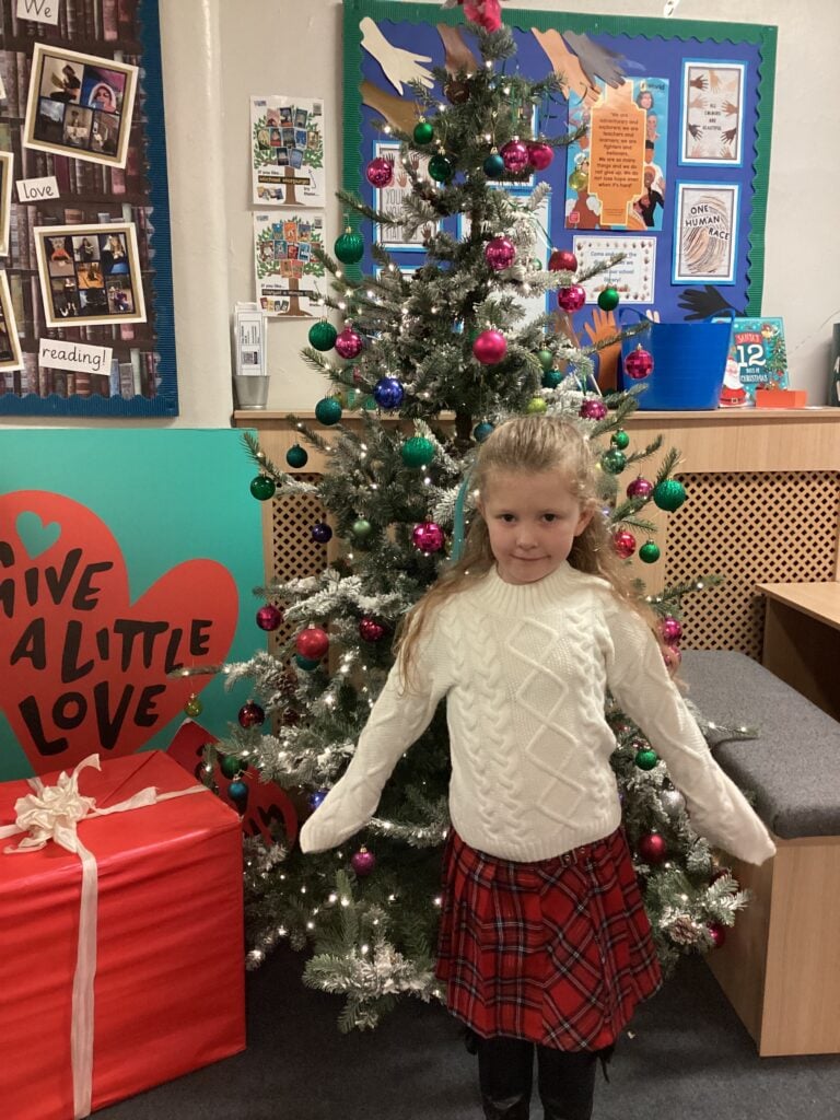 Child standing in front of a Christmas Tree