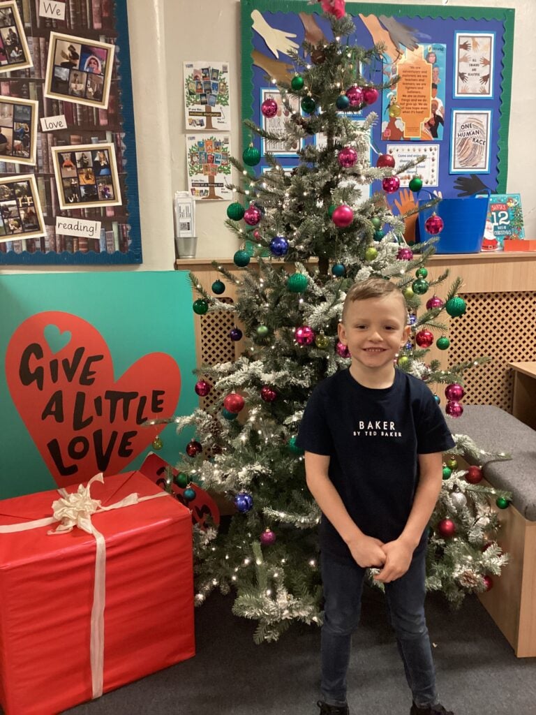 Child standing in front of a Christmas Tree