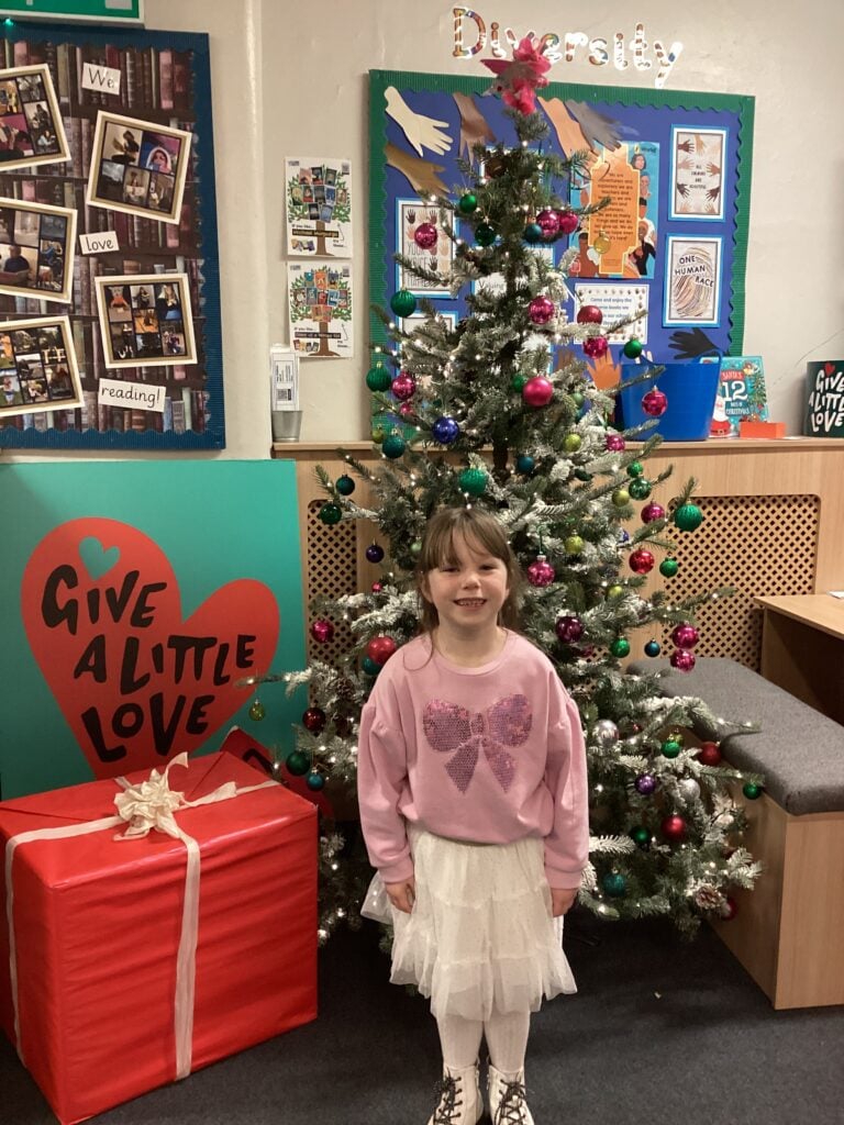 Child standing in front of a Christmas Tree