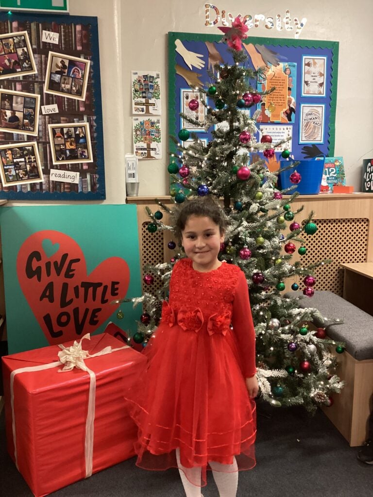 Child standing in front of a Christmas Tree