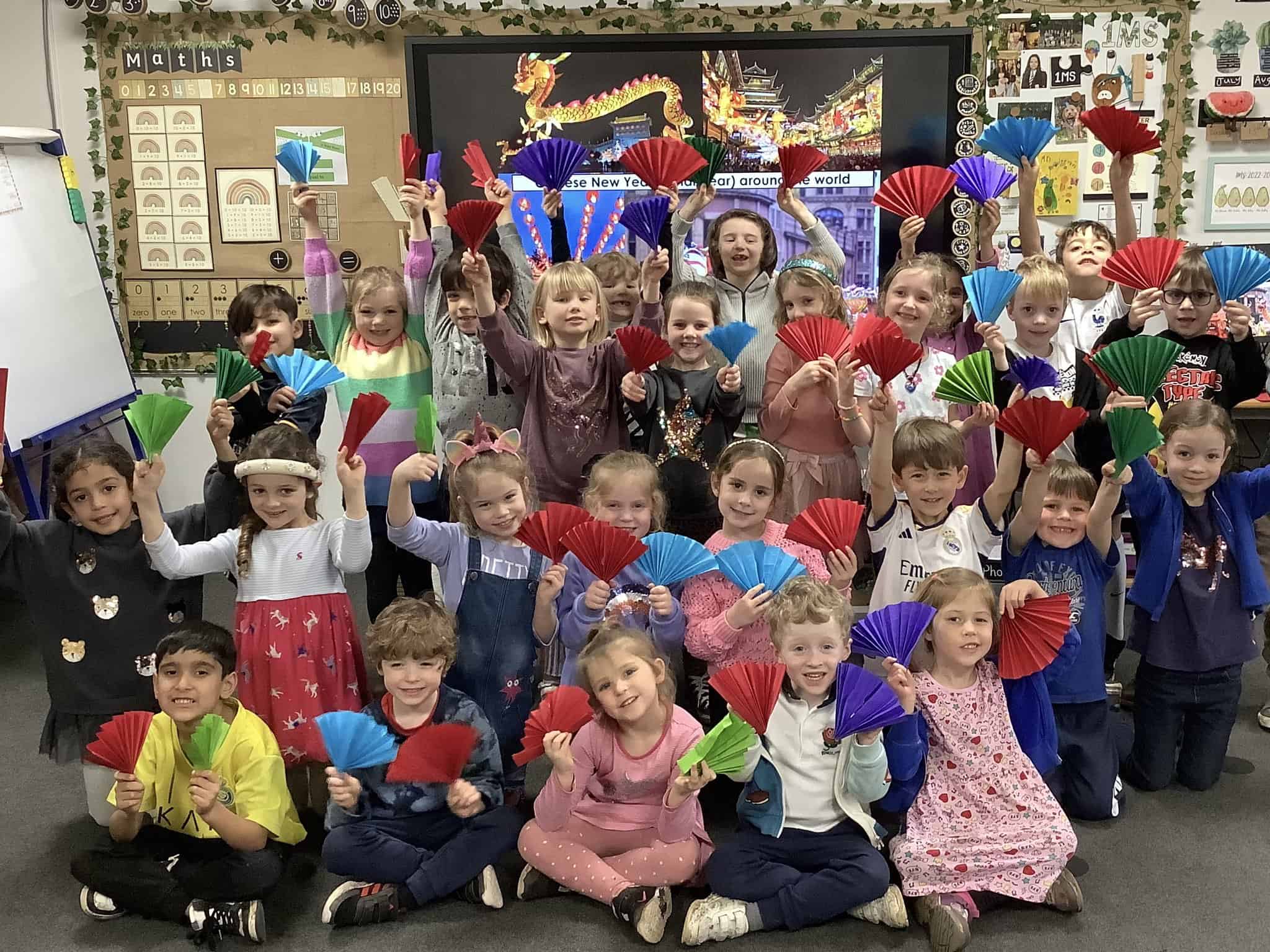 Pupils holding fans and decoration for Chinese New Year.