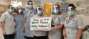 Nurses wearing masks holding a sign that says 'Thank you all at Bishops Primary. Merry Christmas, from everyone at Ward 1 Wansbeck General Hosiptal