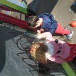 Children playing outside with chalk baord