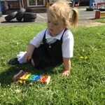 Child outside playing with xylophone