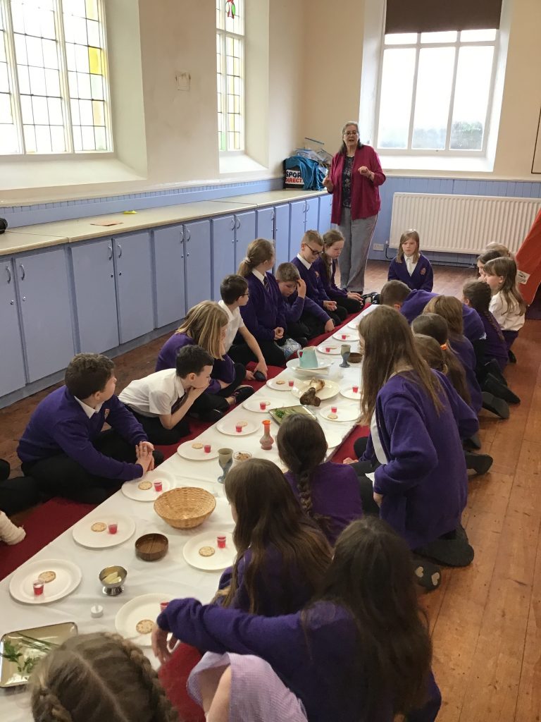 Children sat in hall learning about the Eucharist