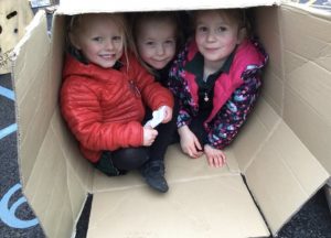 Children smiling in cardboard box