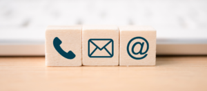 Wooden blocks with phone, email and @ sign on