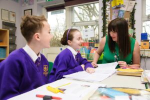 A teacher with pupils at St Bernadette’s Catholic Primary School