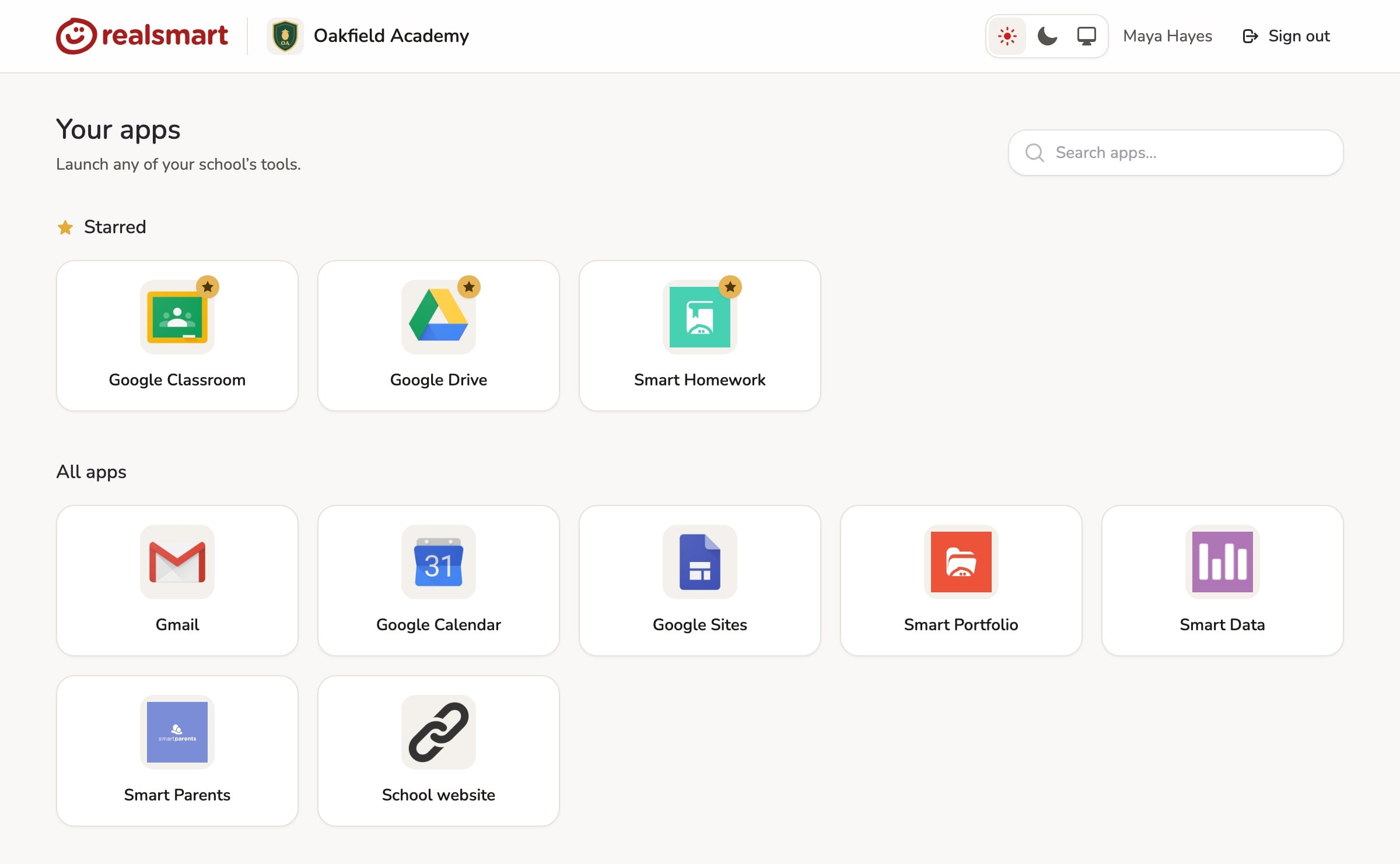 The Realsmart launchpad for a teacher at the demo school Oakfield Academy, showing 'Your apps', a 'Search apps…' box, three starred apps above a grid of all apps, and a light, dark and system appearance toggle.