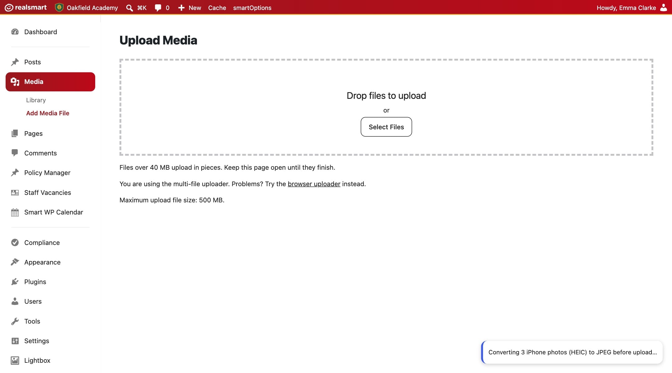 The Upload Media screen on the demo school Oakfield Academy's website, showing a notice that three iPhone photos are being converted from HEIC to JPEG.