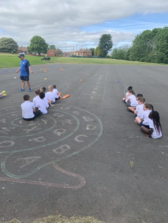 Children enjoying learning how to play cricket