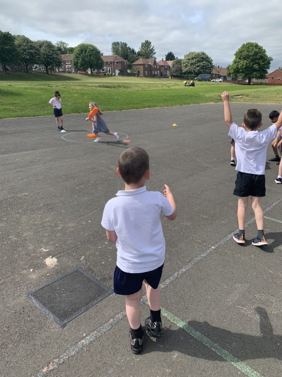 Children enjoying learning how to play cricket