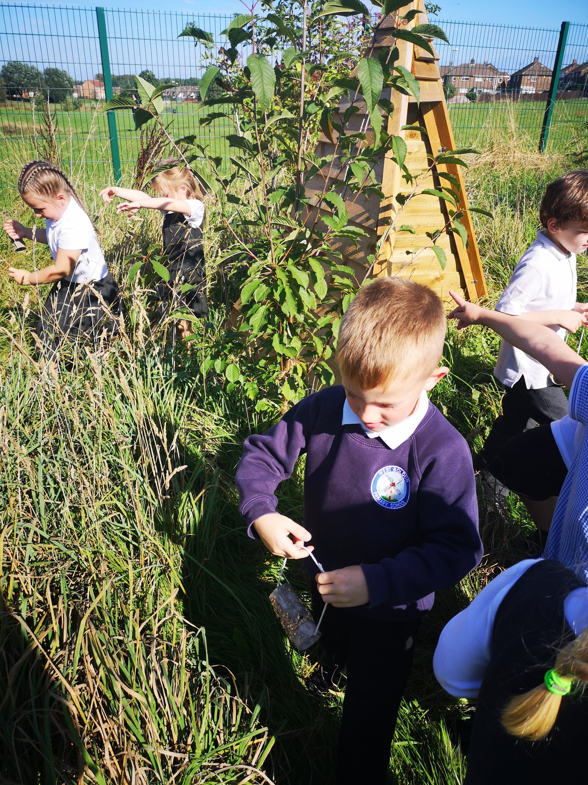 Year 1 children hanging their bird feeders