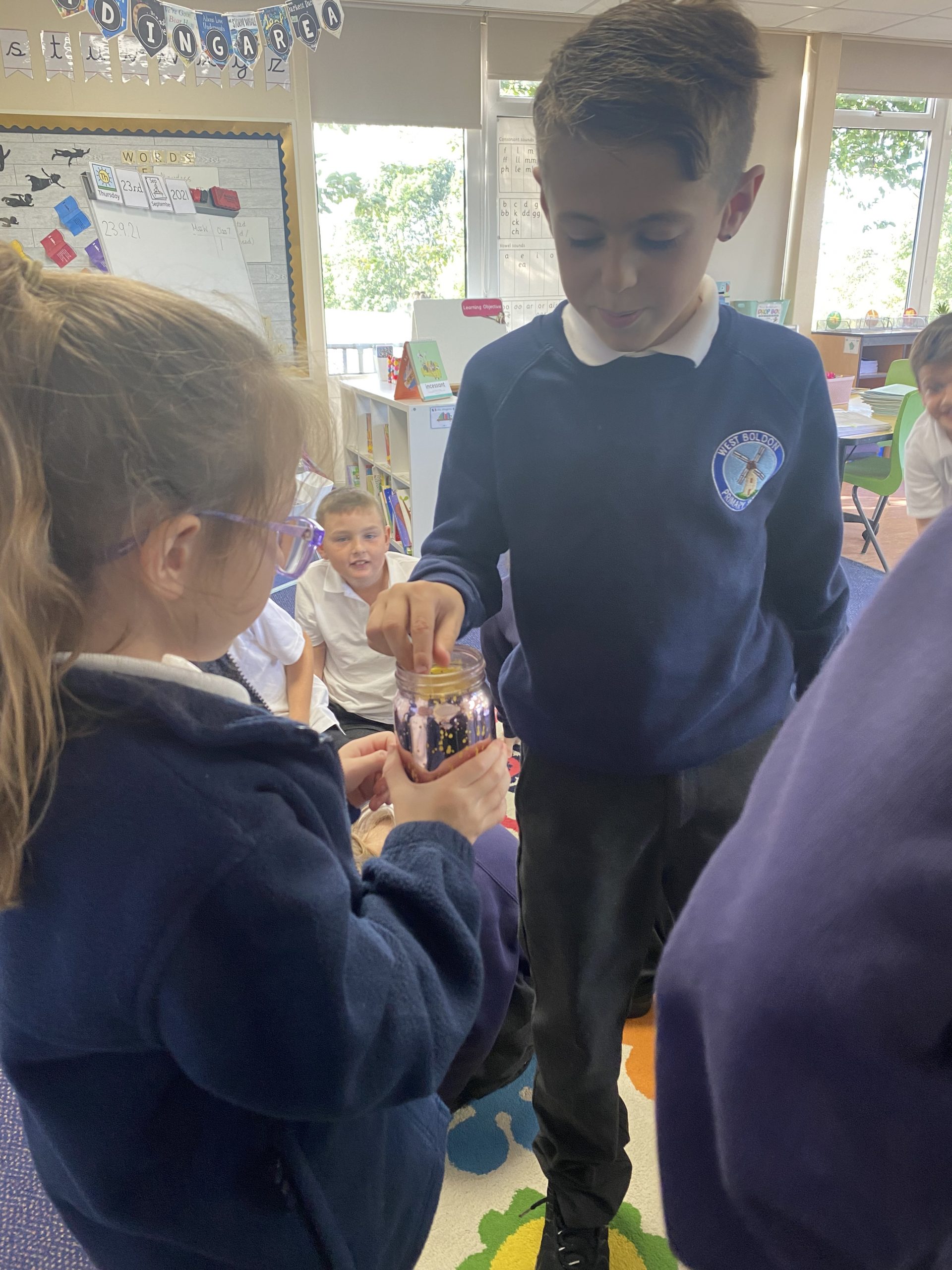 Year 3 putting their secrets in the secret jar