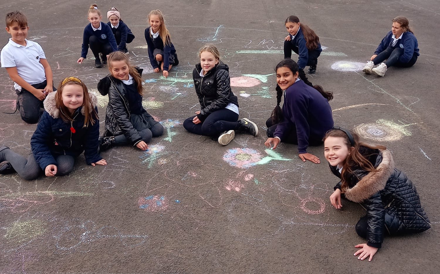 KS2 children enjoying using the chalks to draw during their lunch break