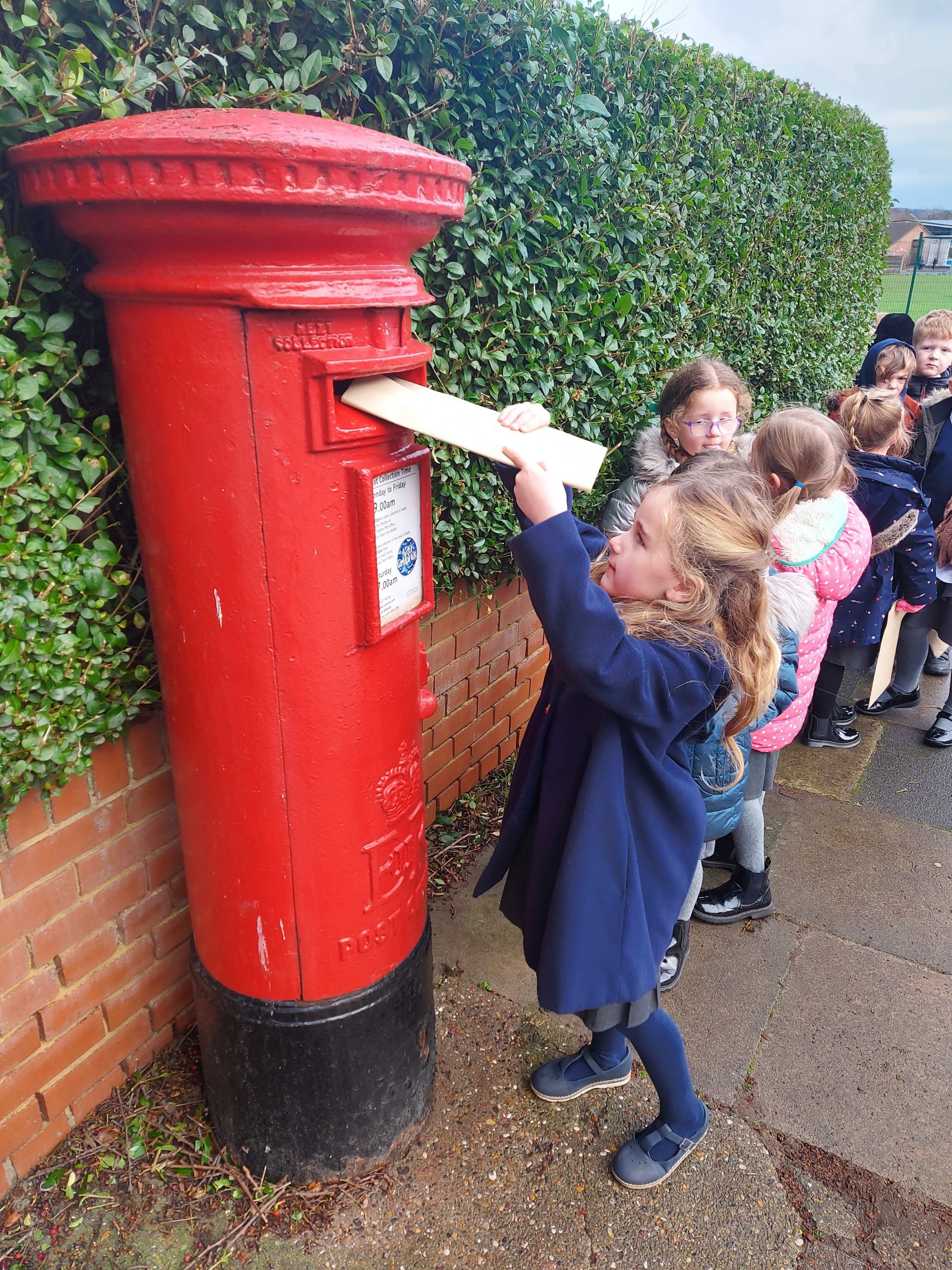 Year 1 children walking to the post box to post their letters to Santa Claus