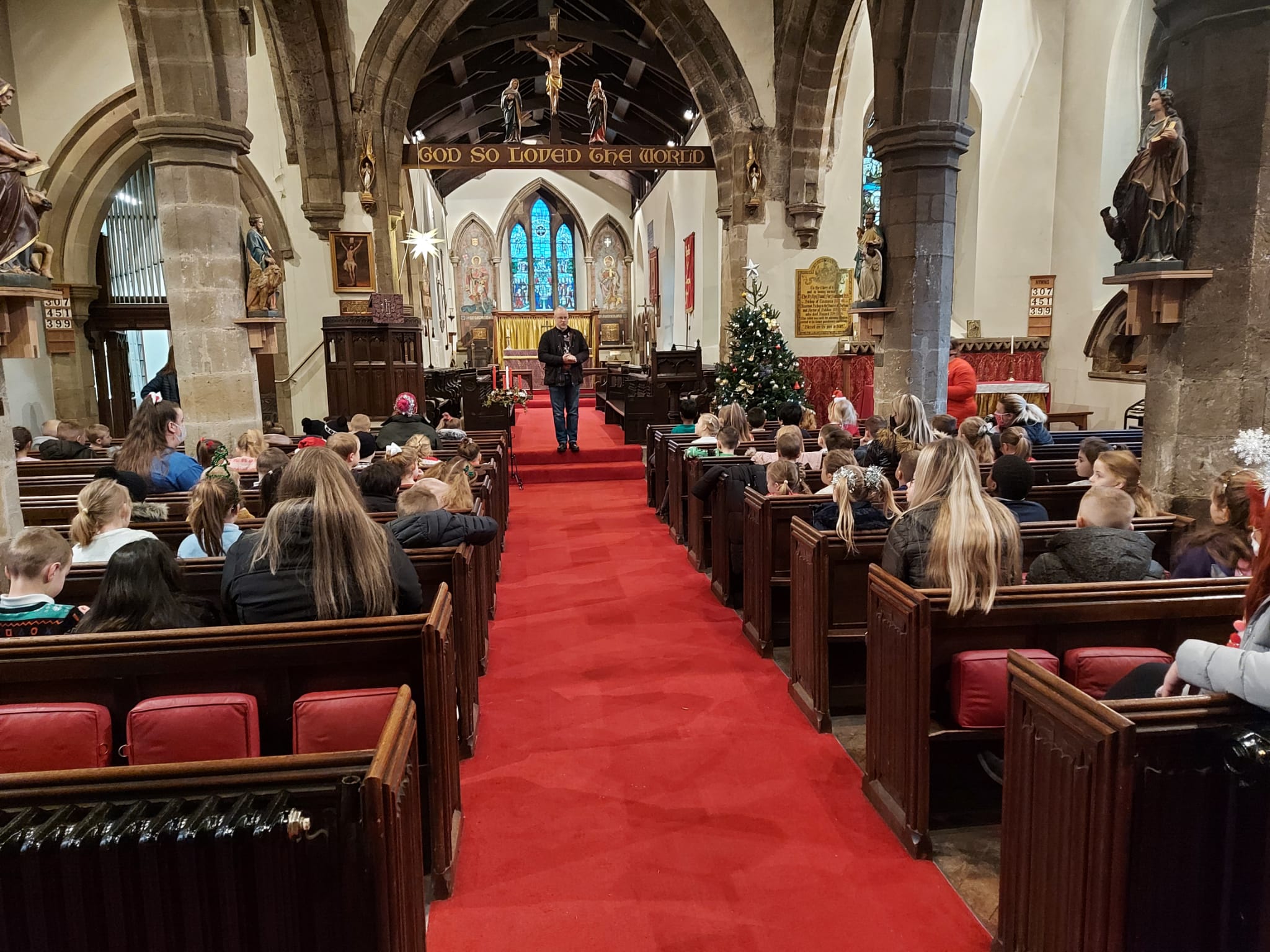 KS1 children listening to Rev Paul