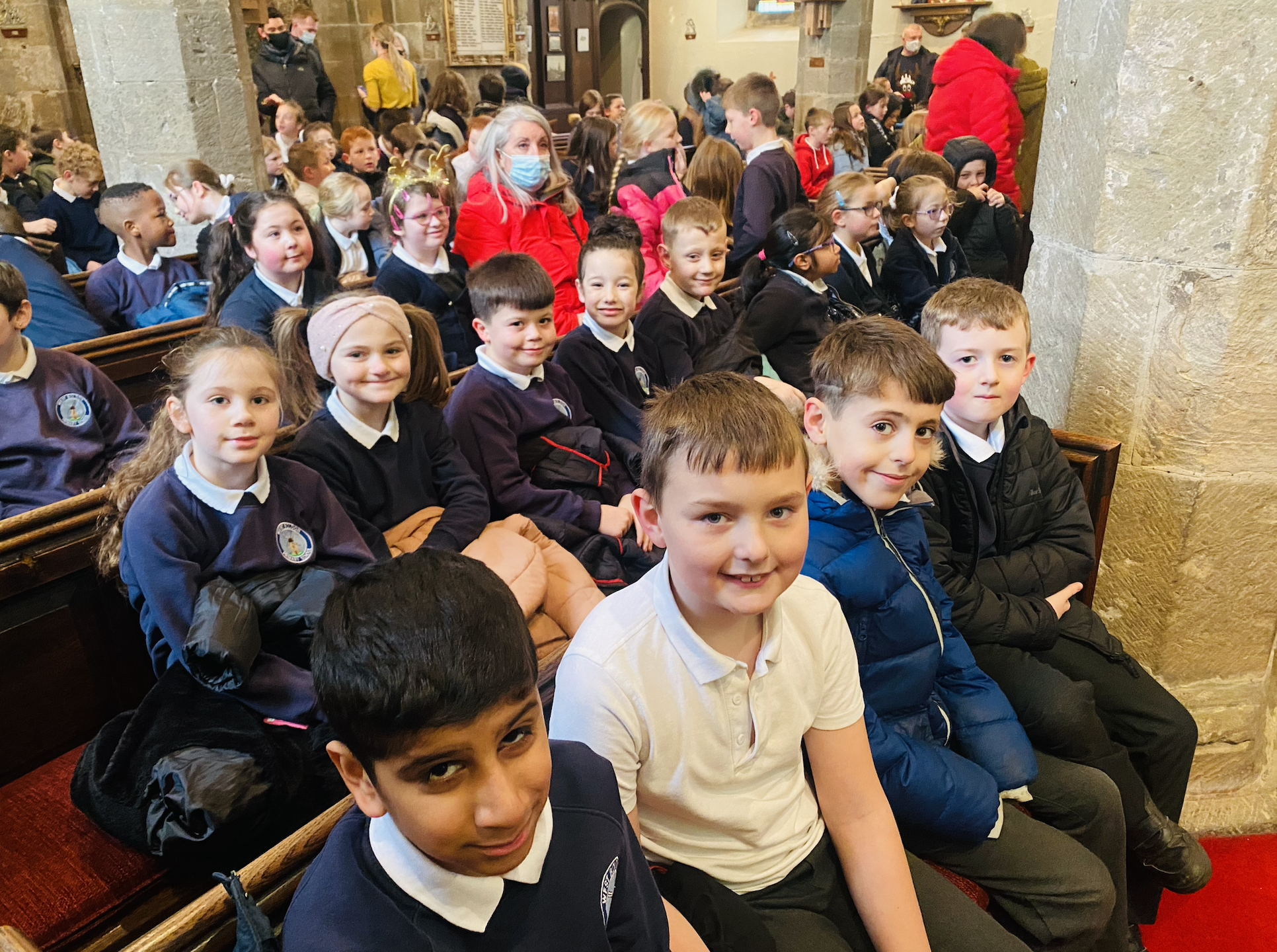 KS2 children listening to Rev. Paul