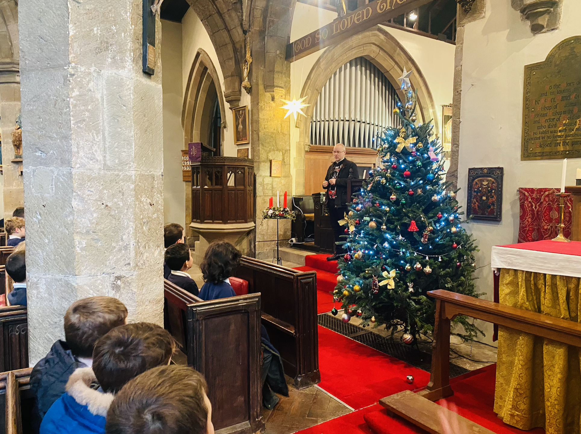 KS2 children listening to Rev. Paul