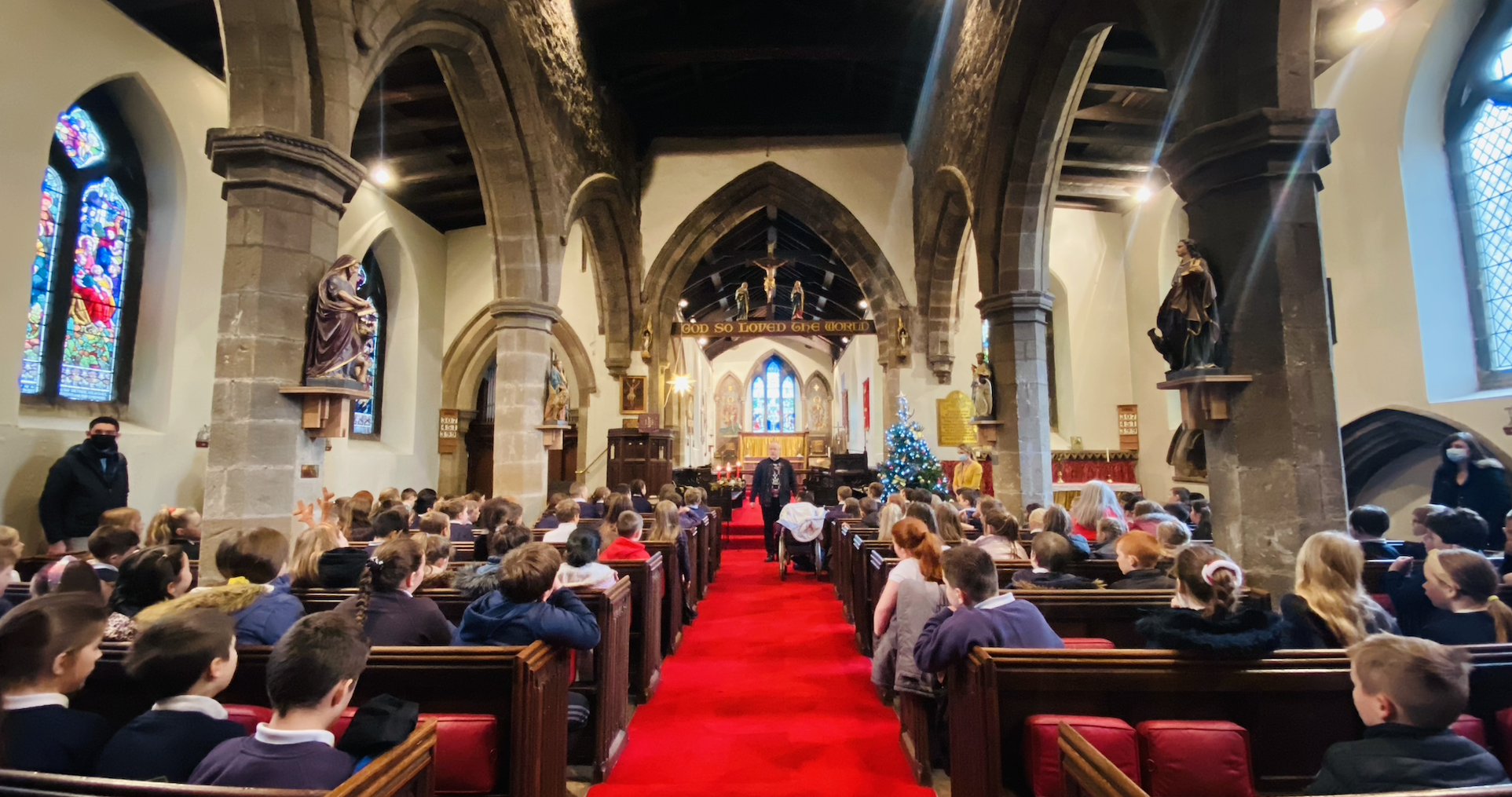 KS2 children listening to Rev. Paul