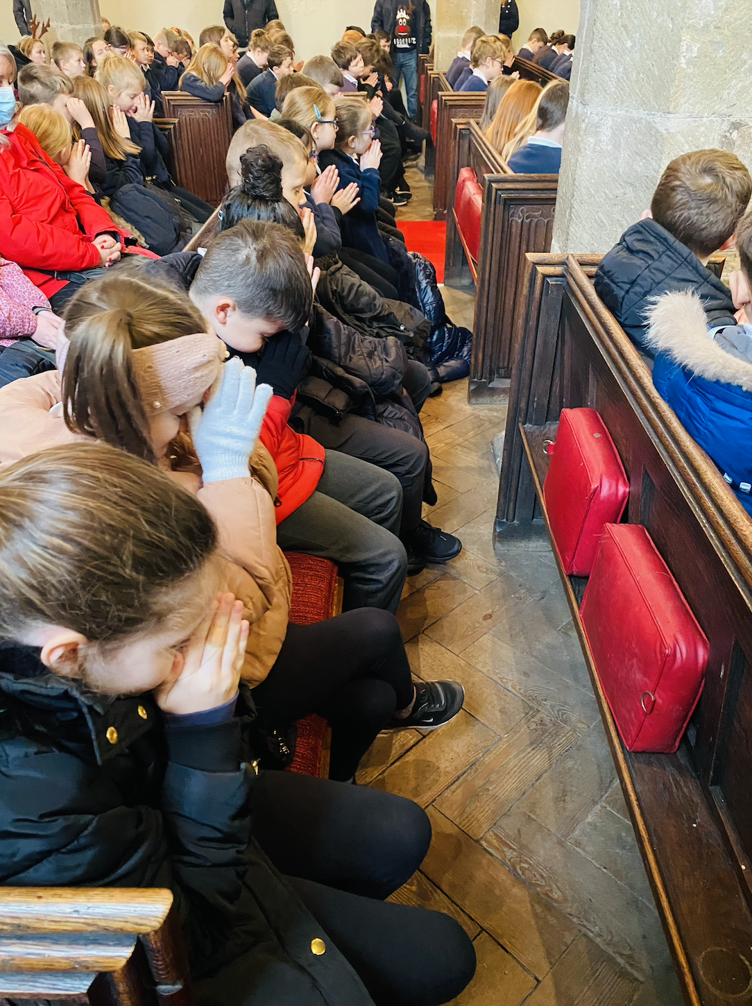 KS2 children saying a prayer at the end of the service