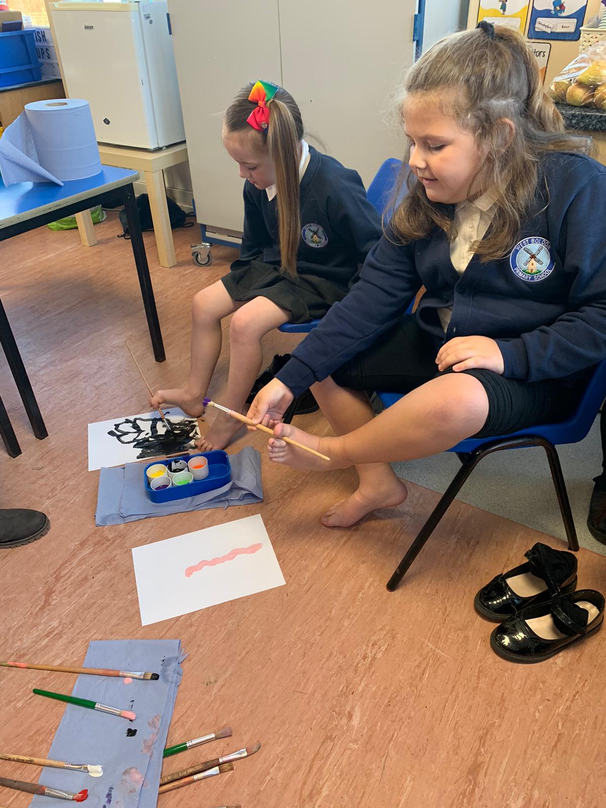 Year 2 children trying to paint with their feet