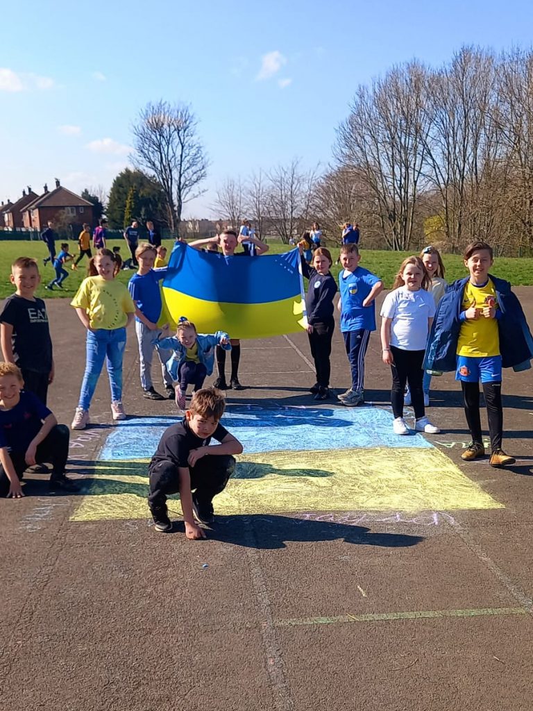 Children drawing Ukraine flags in chalk during lunchtime