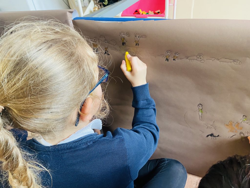 Year 3 children creating their own Stone Age style cave painting