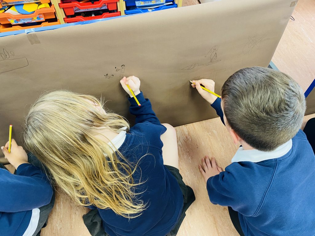 Year 3 children creating their own Stone Age style cave painting
