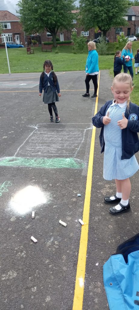 Some of the KS1 children creating images of the Queen with their chalks